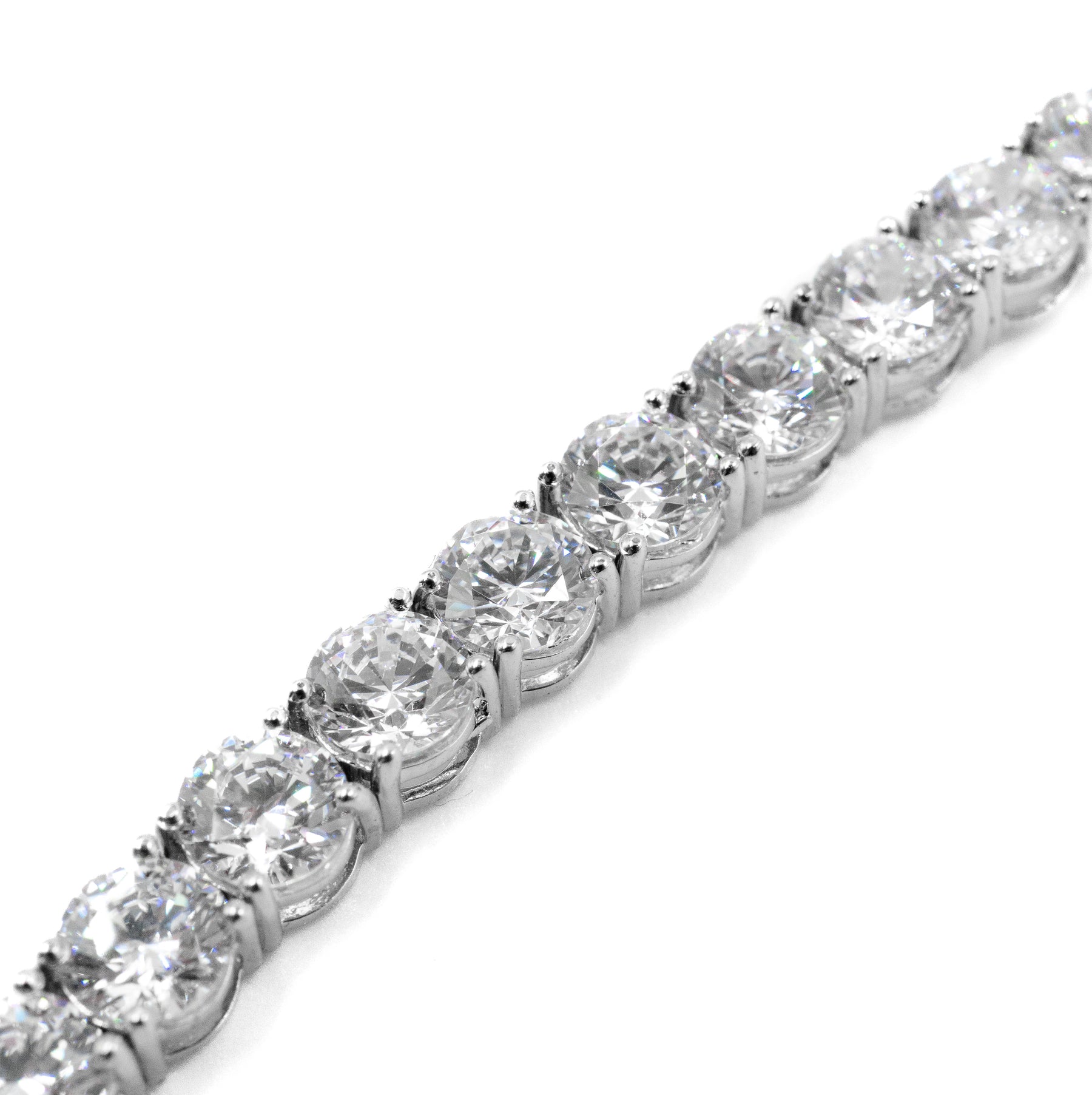 Close-up view of the diamond on a silver tennis bracelet, showcasing the clarity, cut, and brilliance of the stone. Fine jewelry by Carat.Luxury.